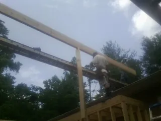 Carpenter setting a ridge beam over a new addition frame — Ice Dam Removal by Roofing Brothers in Lockeford
