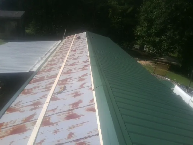 Old rusted panels beside newly installed green metal roofing — Wind Damage Roof Repair by Roofing Brothers in Lockeford