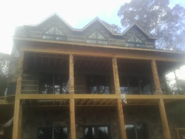 Dormers and porch framing on a large log home under construction — Roof Coating work by our crew in Lockeford